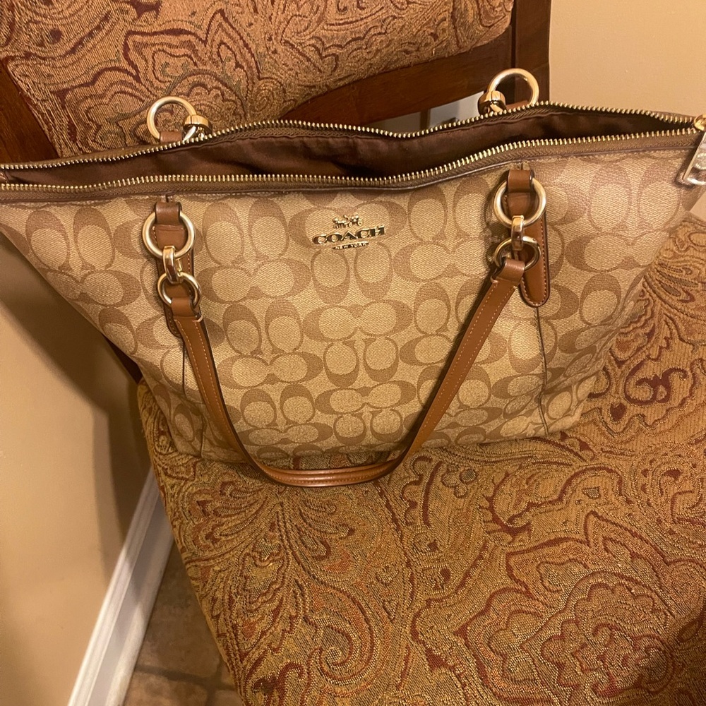 Coach shoulder bag with gold tone zipper and outer front pocket.
